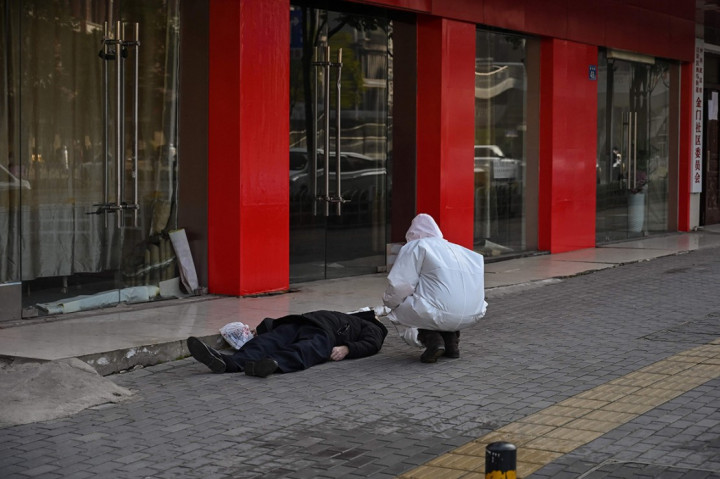 Seorang pria meninggal dan terbaring di trotoar di jalanan Kota Wuhan, Tiongkok, Kamis, 30 Januari 2020. Belum diketahui penyebab kematiannya. AFP PHOTO/Hector Retamal