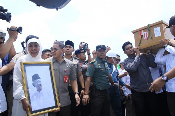 Gubernur Jatim Khofifah Indar Parawansa menyambut kedatangan jenazah KH Salahuddin Wahid atau Gus Sholah yang tiba di Bandara Juanda Surabaya di Sidoarjo, Senin, 3 Februari 2020. Khofifah menangis saat memegang foto Gus Sholah di depan peti jenazah. Dok. Istimewa
