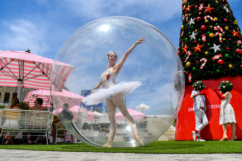 Seorang penari balet berpose dalam gelembung plastik raksasa saat menghibur warga yang berbelanja menjelang libur Natal di Melbourne, Australia pada 13 Desember 2020.