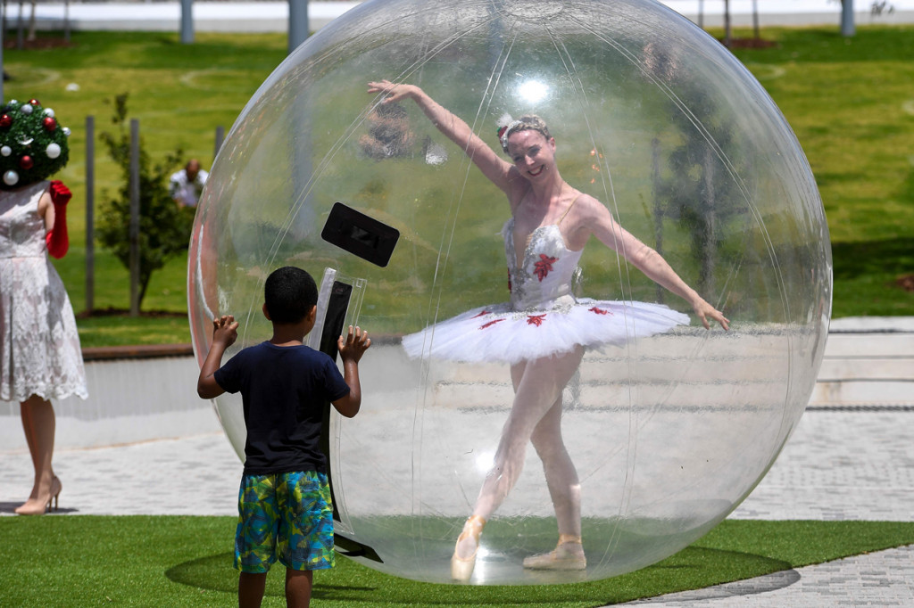 Penari balet di Melbourne, Australia menghibur warga yang berbelanja menjelang libur Natal di tengah pandemi Covid-19 dengan mengenakan gelembung plastik raksasa.