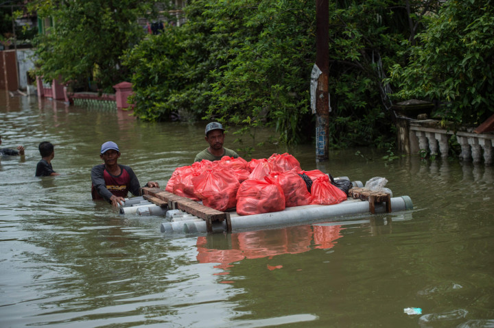 Warga mengevakuasi barang-barang dari rumah mereka yang terendam banjir di Gresik, Jawa Timur.