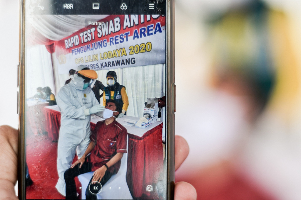 Warga melakukan Rapid Test Antigen yang disediakan oleh Dinas Kesehatan dan Petugas Gabungan dari unsur TNI, Polri dan Satpol PP Provinsi Jawa Barat di Rest Area KM 57, Karawang, Jawa Barat.