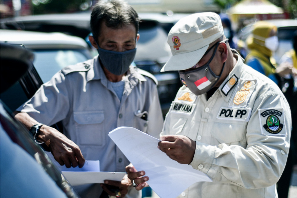 Dinas Kesehatan dan Petugas Gabungan dari unsur TNI, Polri, Dishub dan Satpol PP Provinsi Jawa Barat memeriksa surat keterangan non reaktif covid-19 di Rest Area KM 57, Karawang, Jawa Barat.