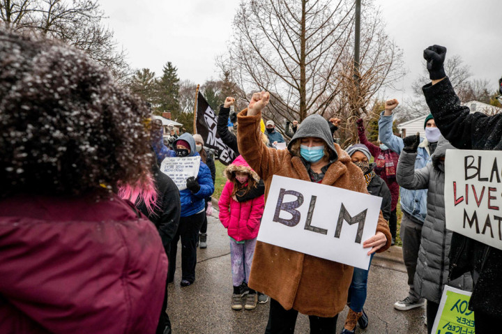 Puluhan pemrotes berkumpul sambil membawa poster bertuliskan 'Black Lives Matter' dan menyerukan keadilan bagi orang-orang yang tewas akibat penembakan polisi.