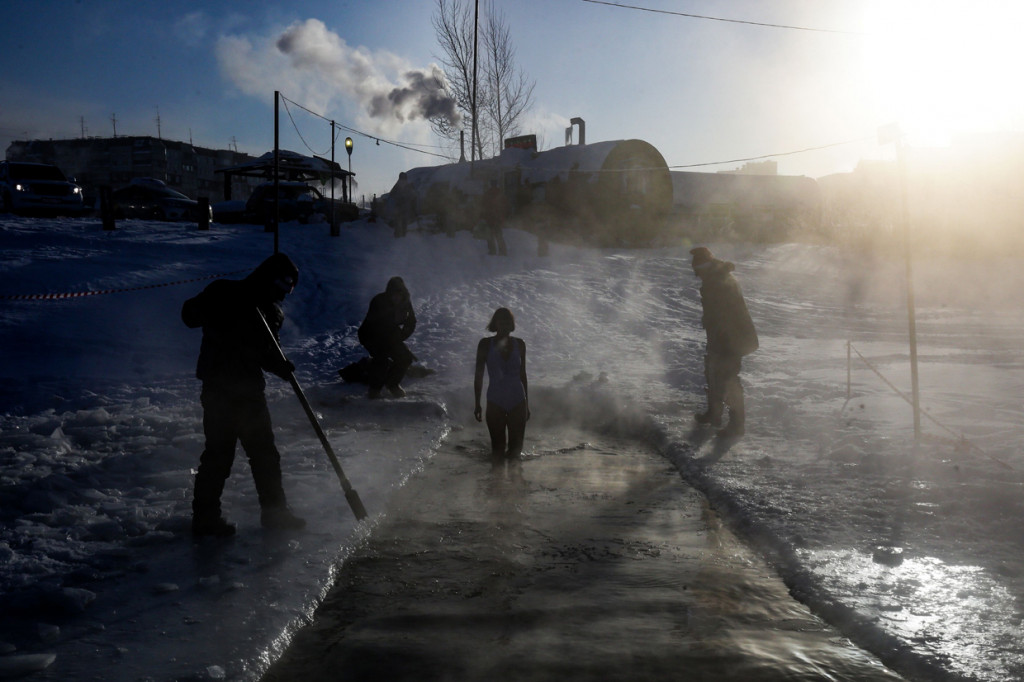 Seorang anggota kub renang es bersiap untuk berenang ke dalam air sedingin es saat suhu tubuh turun hingga 34 derajat celcius, di Novosibirsk, Rusia.
