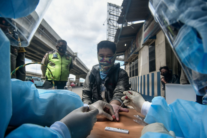 Petugas kesehatan melakukan rapid test pada warga yang terjaring razia protokol kesehatan di Jalan Raya Kalimalang, Bekasi, Jawa Barat.