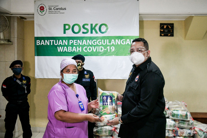 Ketua Dewan Pimpinan Wilayah DKI Jakarta, Garda Pemuda Nasdem Nova Harivan Paloh (kanan) secara simbolis memberikan bantuan pada Kepala Sekretariat dan Rumah Tangga RS St Carolus Dr. Florentina Setiati (kiri) di Jakarta.
