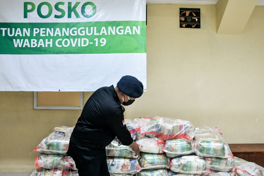 Anggota Garda Pemuda Nasdem menata sejumlah bantuan sembako di Jakarta.
