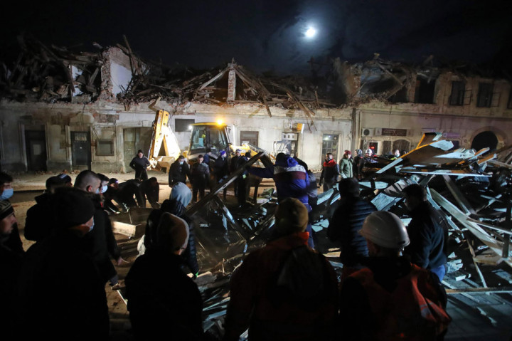 Relawan dan penggemar klub sepak bola Kroasia Dinamo membersihkan puing-puing dari bangunan yang rusak di Petrinja, sekitar 50 km dari Zagreb, setelah kota itu dilanda gempa berkekuatan magnitudo 6,4 pada Selasa, 29 Desember 2020. 