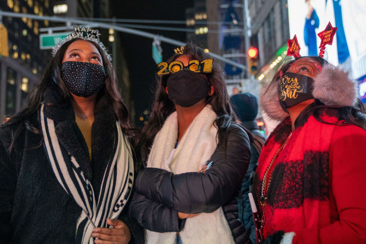 Di Times Square, New York, hanya segelintir tamu undangan, termasuk petugas kesehatan dan lainnya dari garis depan pandemi virus korona yang berkumpul pada Kamis malam untuk menyaksikan jatuhnya bola Malam Tahun Baru, menandai akhir dari 2020 dan awal yang penuh harapan untuk 2021.