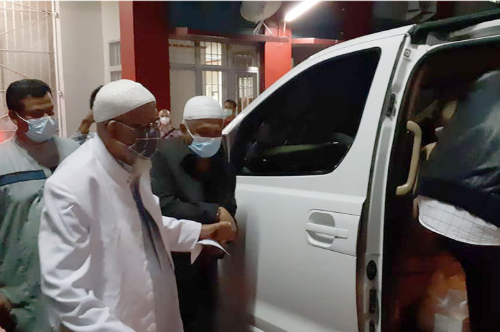 Abu Bakar Ba'asyir nampak mengenakan pakaian serba putih, kaca mata, dan masker dalam minibus putih jenis Hyundai berplat nomor AD 1138 WA.