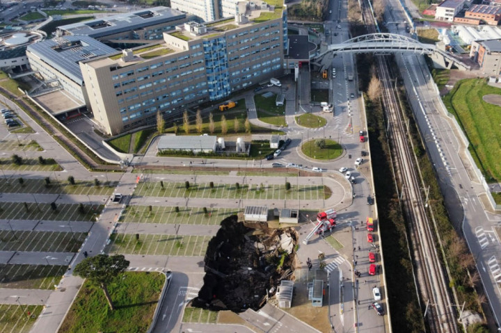Lubang besar terbuka (sinkhole) tiba-tiba muncul di tempat parkir mopbil di luar rumah sakit khusus pasien covid-19 di Naples, Napoli, Jumat, 8 Januari 2021 pagi waktu setempat. Para pasien covid-19 terpaksa dievakuasi akibat kejadian tersebut.