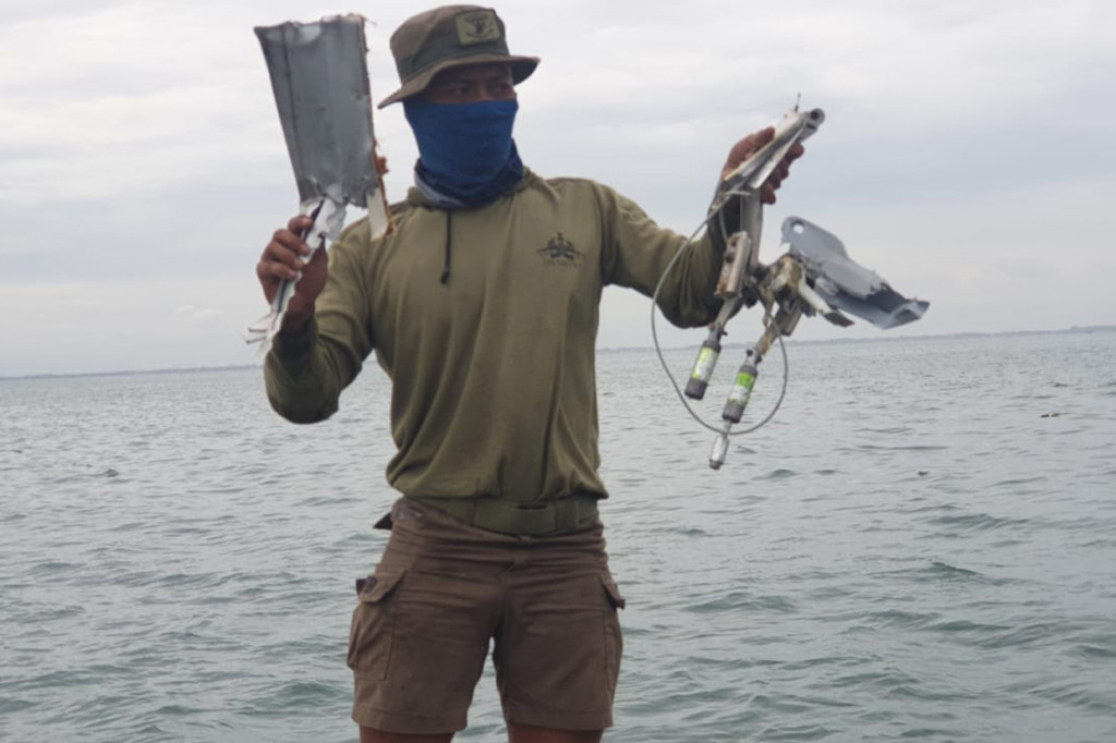 Anggota TNI AL memperlihatkan serpihan diduga pesawat Sriwijaya Air SJ-182 yang ditemukan dari perairan Kepulauan Seribu.