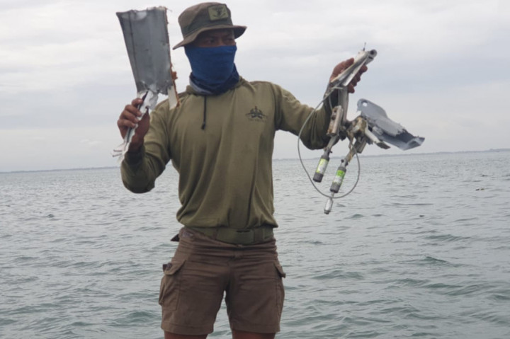 Anggota TNI AL memperlihatkan serpihan diduga pesawat Sriwijaya Air SJ-182 yang ditemukan dari perairan Kepulauan Seribu.