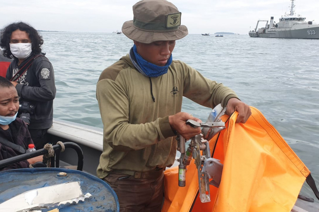 Anggota TNI AL memeriksa serpihan diduga pesawat Sriwijaya Air SJ-182 yang ditemukan dari perairan Kepulauan Seribu.
