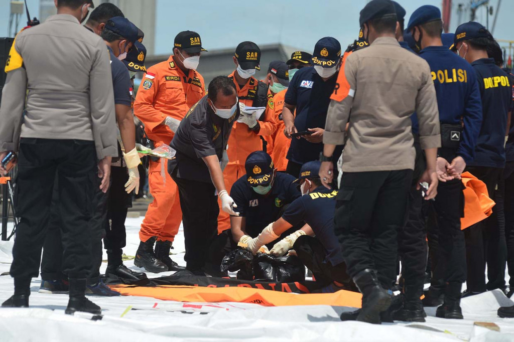 Anggota Badan SAR Nasional (Basarnas) menurunkan bagian tubuh korban Sriwijaya Air S-J182 yang ditemukan di perairan menggunakan Kapal Motor SAR Basudewa di Jakarta International Container Terminal (JICT), Tanjung Priok, Jakarta.