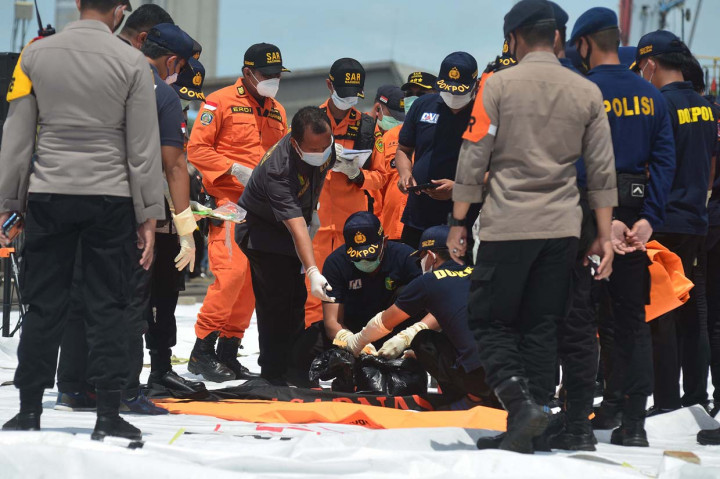 Anggota Badan SAR Nasional (Basarnas) menurunkan bagian tubuh korban Sriwijaya Air S-J182 yang ditemukan di perairan menggunakan Kapal Motor SAR Basudewa di Jakarta International Container Terminal (JICT), Tanjung Priok, Jakarta.