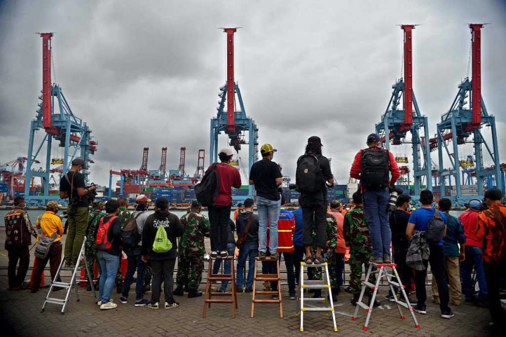 Jurnalis bertugas memantau serpihan badan pesawat Sriwijaya Air S-J182 di Jakarta International Container Terminal (JICT), Tanjung Priok, Jakarta.