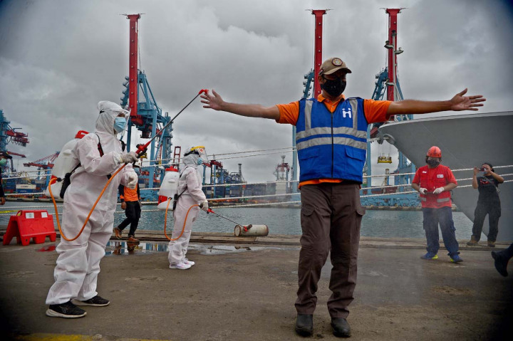 Petugas disemprot cairan disinfektan usai menata serpihan badan pesawat Sriwijaya Air S-J182 di Jakarta International Container Terminal (JICT), Tanjung Priok, Jakarta.