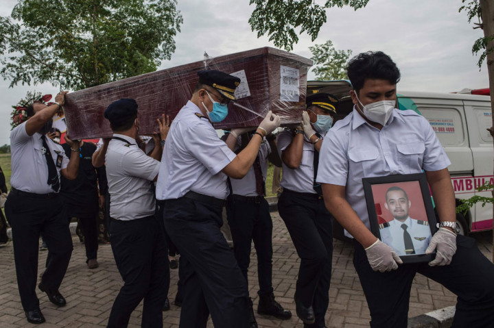Sejumlah rekan mengusung peti jenazah Fadly Satrianto, yang menjadi salah satu korban jatuhnya pesawat Sriwijaya Air SJ-182 saat prosesi pemakaman di TPU Keputih, Surabaya, Jawa Timur, Jumat, 15 Januari 2021.