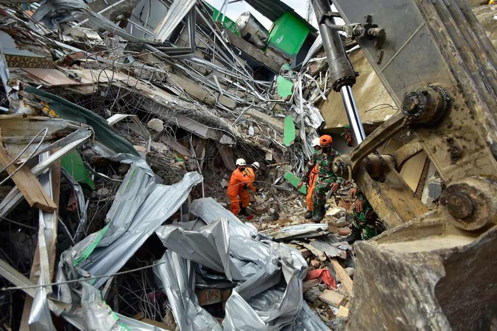 Tim penyelamat bergegas untuk menemukan korban yang terkubur reruntuhan bangunan, setelah gempa bumi dahsyat melanda Majene, Mamuju, Sulawesi Barat, pada Jumat, 15 Januari 2021 dini hari kemarin.