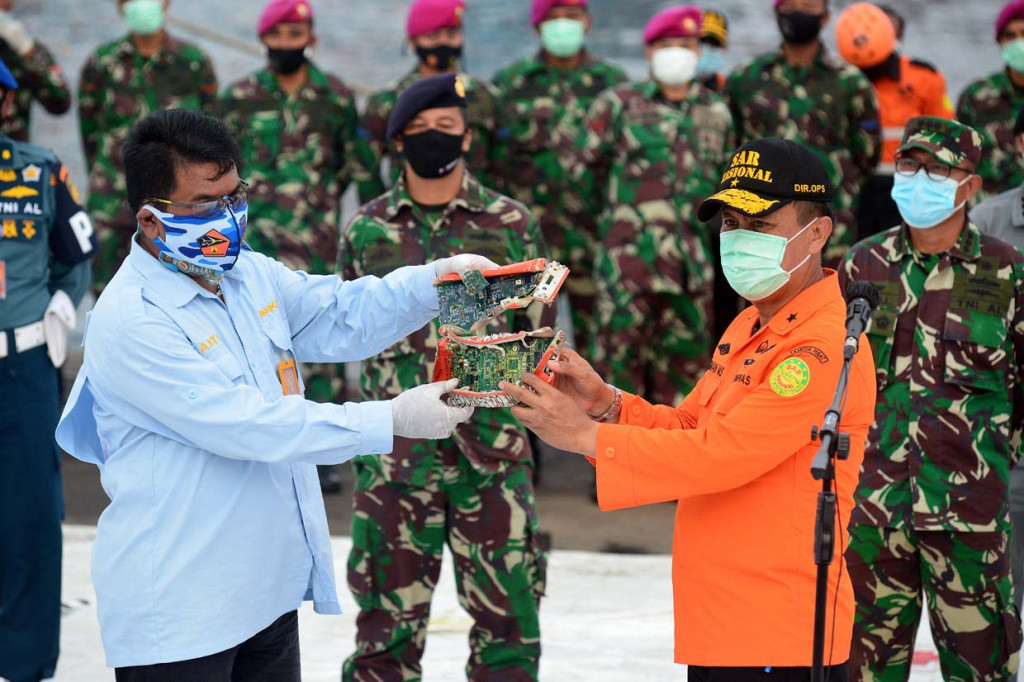 Direktur Operasi Basarnas Brigjen TNI (MAR) Rasman (kanan) menyerahkan modul kotak penyimpanan Cockpit Voice Recorder (CVR) kepada pihak Komite Nasional Keselamatan Transportasi (KNKT) yang dibawa KRI Kurau setibanya di posko pencarian Sriwijaya Air S-J182 di Jakarta International Container Terminal (JICT) II, Tanjung Priok, Jakarta.