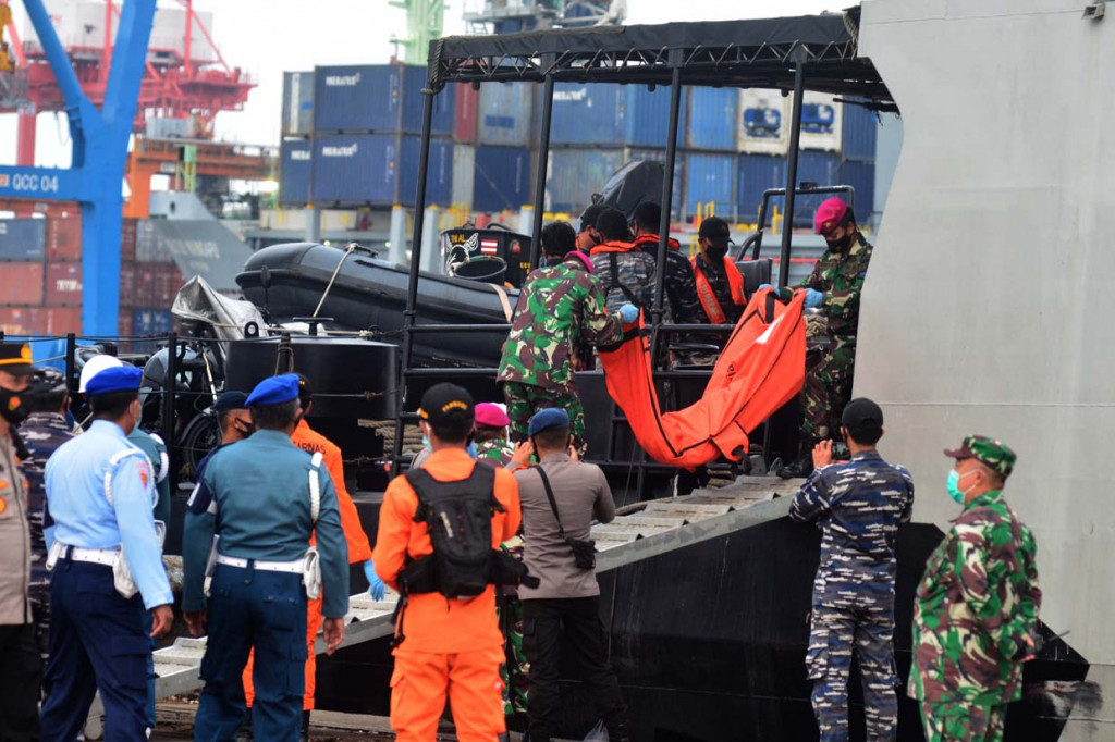 Petugas membawa potongan tubuh dan serpihan pesawat dari KRI Kurau setibanya di posko pencarian Sriwijaya Air S-J182 di Jakarta International Container Terminal (JICT) II, Tanjung Priok, Jakarta.