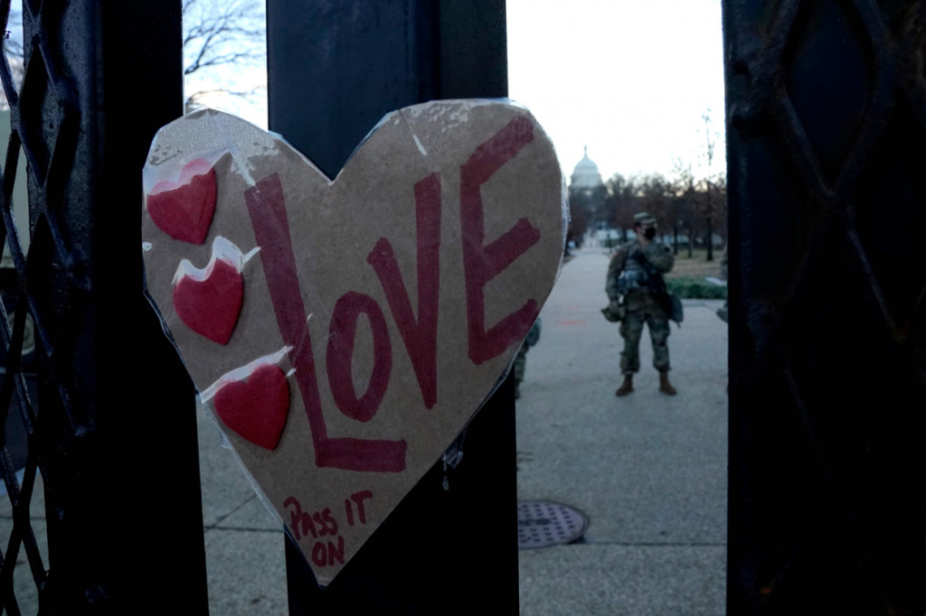 Sebuah tanda bertuliskan Cinta diletakkan pada pagar pembatas di luar Gedung Capitol Hill, AS, yang dijaga ketat oleh Pasukan Garda Nasional. AFP Photo/Timothy A. Clary