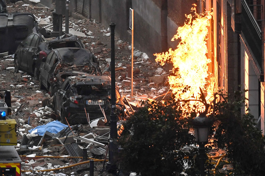 Api membubung tinggi, sementara mobil-mobil mengalami rusak parak setelah sebuah ledakan besar mengguncang sebuah gedung di Kota Madrid, Spanyol, Rabu, 20 Januari 2021 waktu setempat.