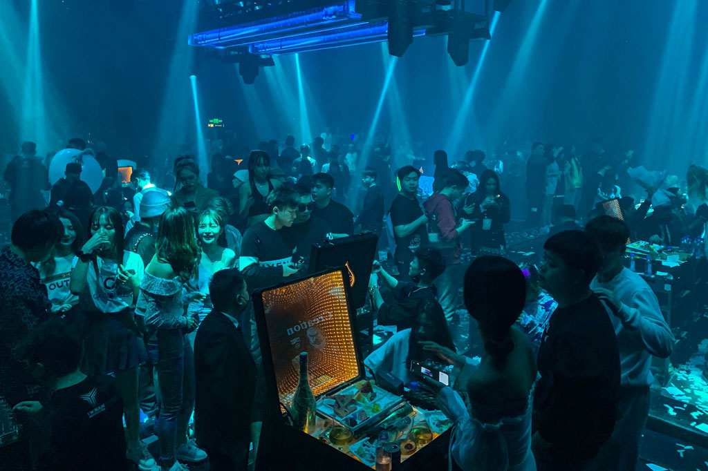 Di dalam, di mana para clubbers bersantai di lantai dansa di tengah suara techno yang memekakkan telinga dan pertunjukan laser yang membutakan, peraturan tidak selalu diikuti dengan ketat. Sementara masker wajib ada di depan pintu, DJ dan pengunjung pesta melepasnya untuk mengobrol dengan teman, menari, atau merokok.