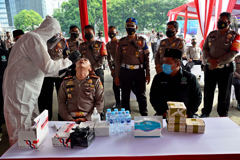 Dirlantas Polda Metro Jaya Kombes Sambodo Purnomo (kiri) didampingi Ketua Umum PP Pagar Nusa Nabil Haroen diambil sampel saat swab antigen massal petugas Patroli Jalan Raya (PJR) Polda Metro Jaya di Jakarta, Sabtu, 23 Januari 2021.