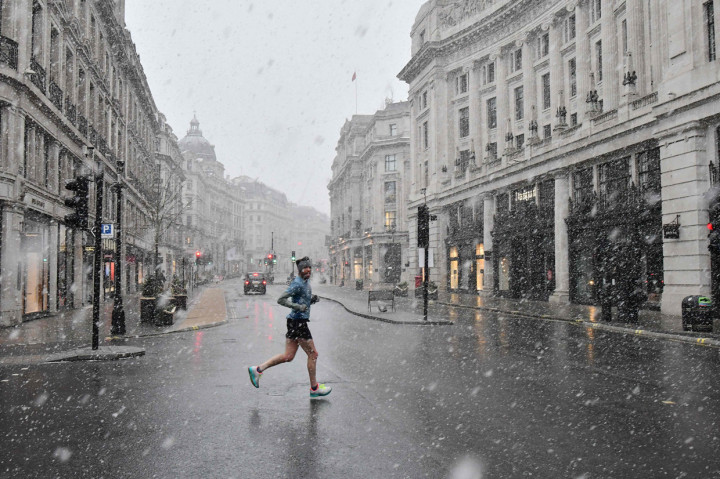 Warga berolahraga melintasi Regent Street di London saat ibu kota Inggris mengalami hujan salju yang jarang terjadi.