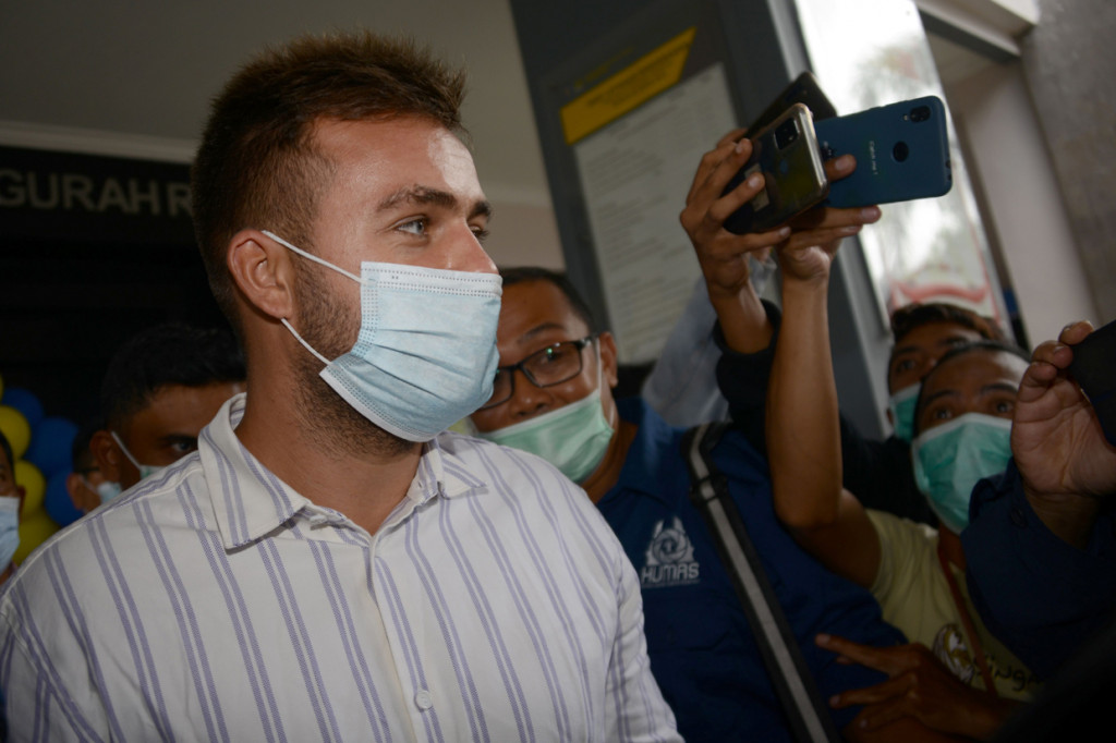 Fotonya diambil pada 24 Januari 2021 menunjukkan warga negara Rusia Sergey Kosenko (kiri) sedang dikawal dari kantor imigrasi ke Bandara Ngurah Rai di Jimbaran, Bali.