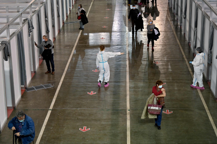 Orang-orang keluar ruangan setelah menerima vaksin Covid-19 di pusat vaksinasi makeshift Beograd Fair, Serbia.
