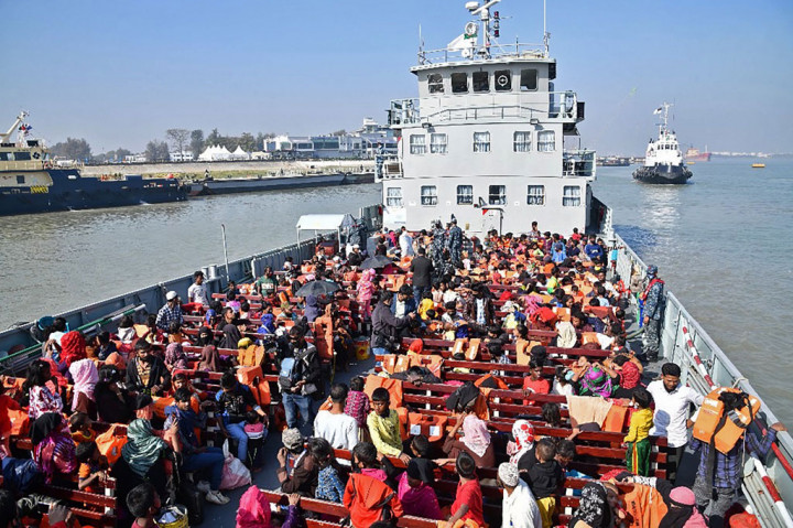 Sebuah kapal Angkatan Laut yang penuh dengan migran di dek atasnya berangkat dari kota pelabuhan Chittagong pada Jumat.