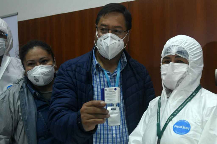 Presiden Bolivia Luis Arce (tengah) menunjukkan paket vaksin Sputnik V (Gam-COVID-Vac) Rusia saat negara tersebut memulai melakukan vaksinasi di rumah sakit umum di Santa Cruz, pada Jumat, 29 Januari 2021 waktu setempat.