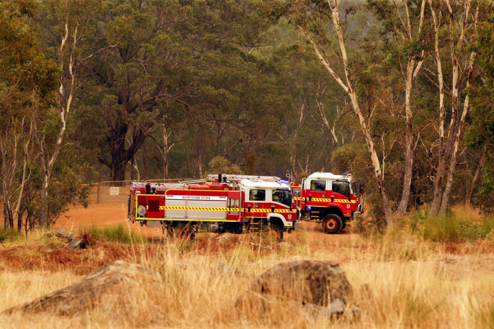 Truk pemadam kebakaran bersiap memadamkan api yang berkobar di punggung bukit di pinggiran Brigadoon di Perth.