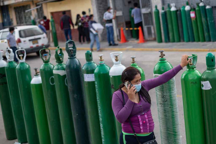 Ratusan tabung oksigen seukuran manusia berjejer di jalan di luar pabrik oksigen kecil Criogas di kota pelabuhan El Callao, dekat ibu kota Lima, masing-masing bertuliskan nama orang yang membawanya. 