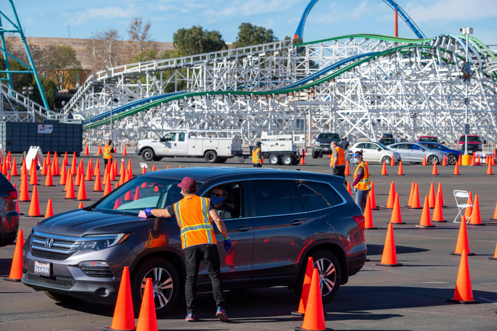 Relawan memandu pengendara di pusat vaksinasi COVID-19 drive-thru massal di tempat parkir Six Flags Magic Mountain di Valencia, California.