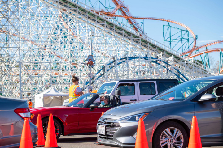 Orang-orang duduk di dalam mobil mereka di area observasi untuk memeriksa kemungkinan efek samping setelah mendapatkan suntikan vaksin di pusat vaksinasi Covid 19 skala besar yang didirikan di Six Flags Magic Mountain di Valencia, California.