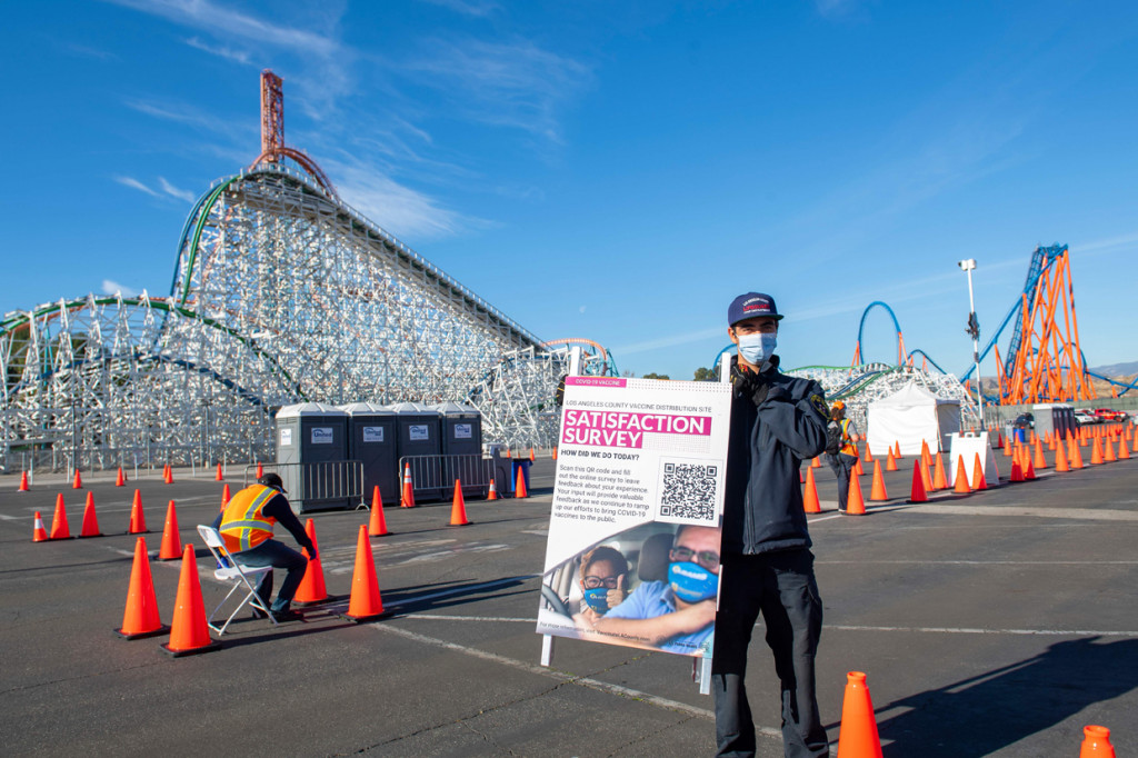 Seorang petugas kesehatan menampilkan papan di pusat vaksinasi Covid-19 skala besar yang didirikan di Six Flags Magic Mountain di Valencia, California.