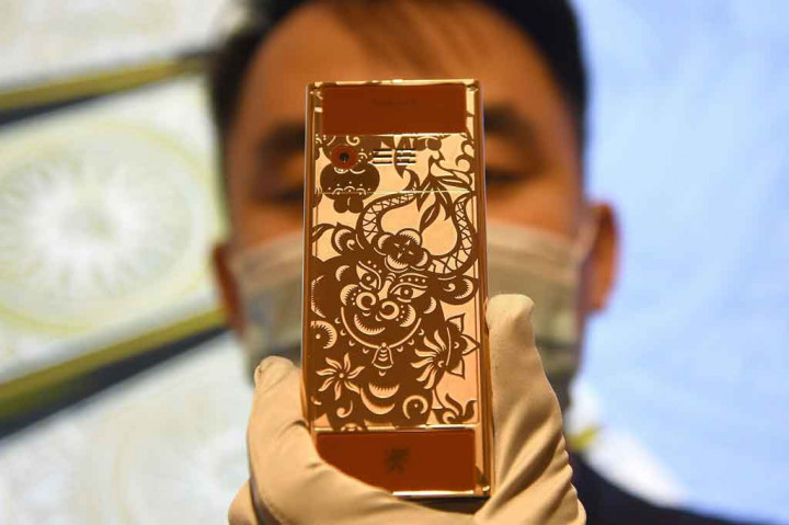 Karyawan memperlihatkan ponsel edisi terbatas untuk menyambut Tahun Baru Imlek 2572 di sebuah toko pembuat telepon seluler di Vietnam.