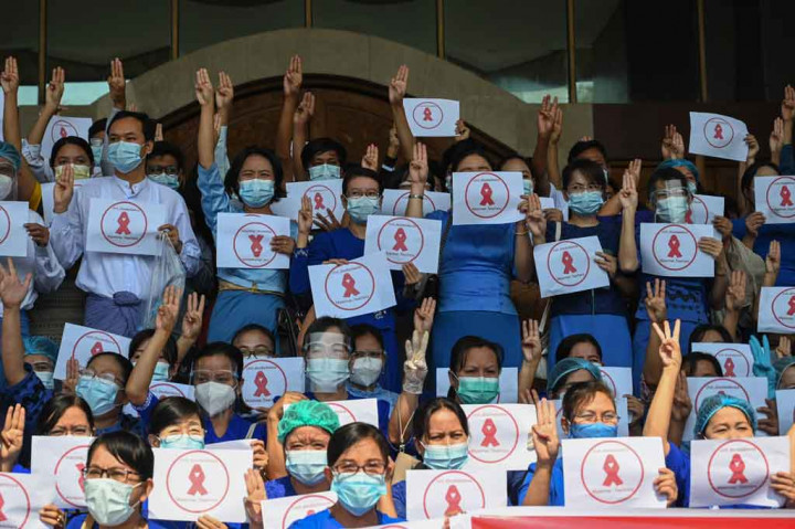 Mahasiswa universitas menunjukkan simbol tiga jari dan pita merah yang menyerukan pembangkangan sipil selama protes melawan kudeta militer, di Universitas Dagon di Yangon pada Jumat, 5 Februari 2021.