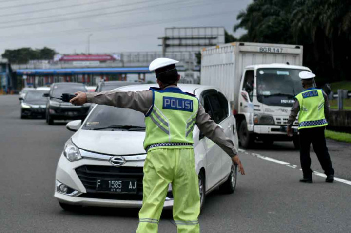 Petugas gabungan dari Dishub Kota Bogor, Satpol PP Kota Bogor, Polisi Militer, dan Polresta Bogor Kota mengarahkan kendaraan roda empat berplat ganjil untuk memutar balik saat pemberlakuan aturan ganjil-genap di pos sekat Gerbang Tol Bogor, Tanah Baru, Kota Bogor, Jawa Barat, Sabtu, 6 Februari 2021. 