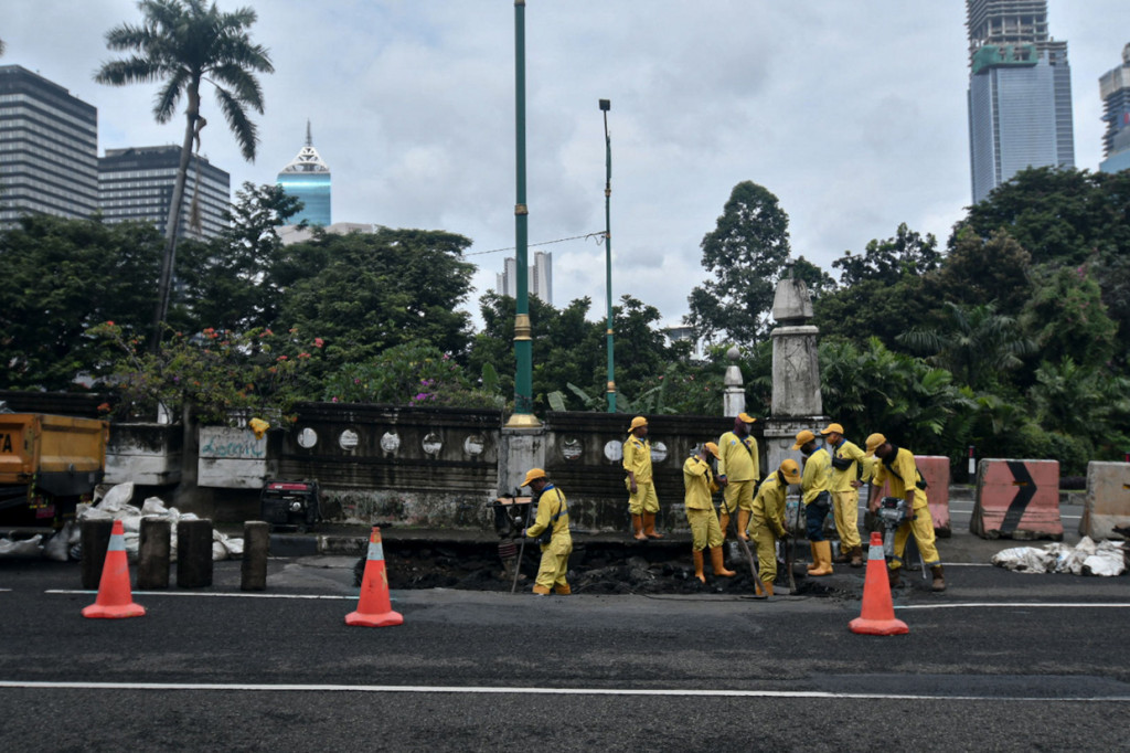 Petugas Sudin Bina Marga Jakarta Pusat memperbaiki aspal jembatan yang ambles di Jalan HOS Cokroaminoto, Jakarta Pusat.