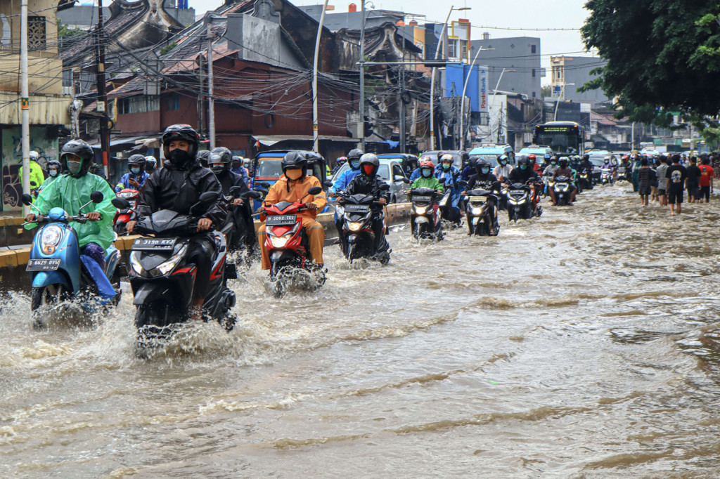 Kendaraan melintas genangan air di Kawasan Jatinegara, Kampung Melayu, Jakarta.