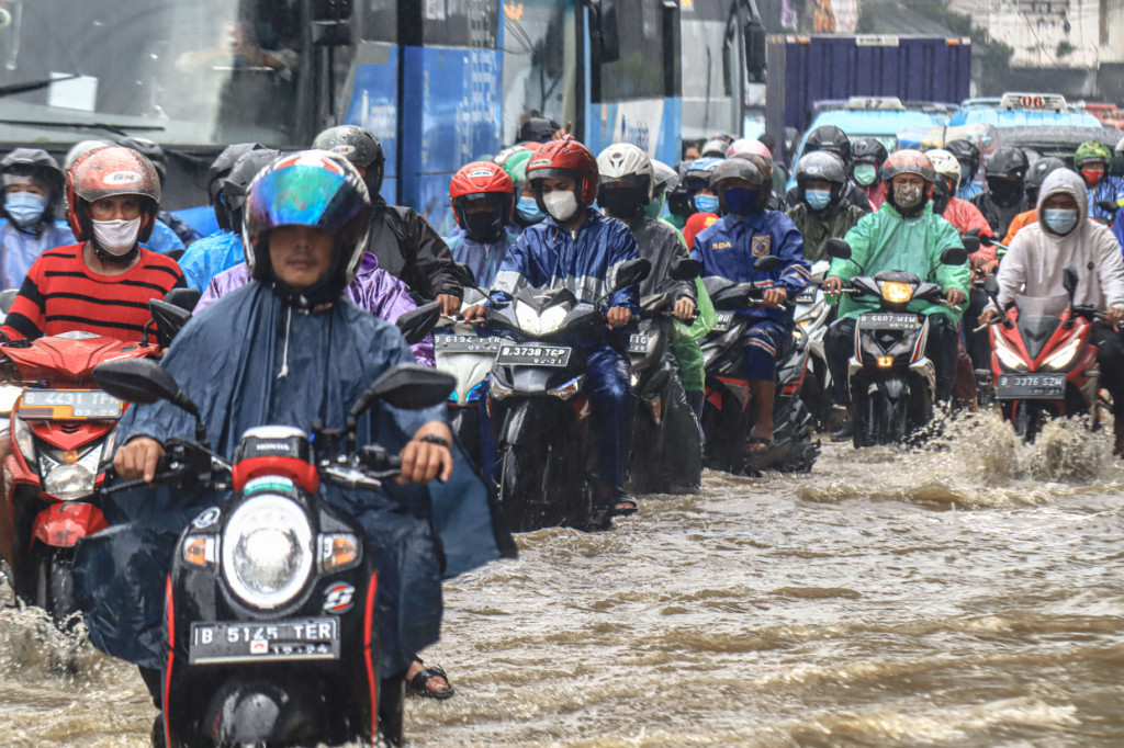 Arus lalu lintas di Jalan Jatinegara Barat, Jakarta Timur, tersendat akibat sebagian badan jalan terendam banjir luapan Sungai Ciliwung dengan ketinggian sekitar 20 sentimeter.