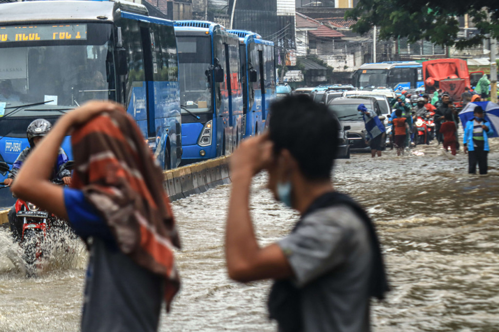 Genangan air dipicu luapan dari Sungai Ciliwung yang berada di sisi jalan. Air dari sungai merembes ke sejumlah saluran pembuangan air dan luber ke badan Jalan Jatinegara Barat.