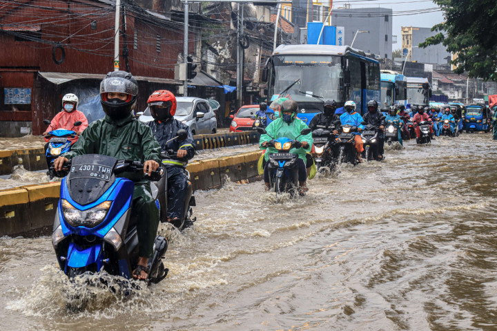 Kendaraan seperti TransJakarta maupun angkot dan kendaraan pribadi masih bisa melintas walaupun air luapan sungai menutup lebih dari separuh badan jalan.