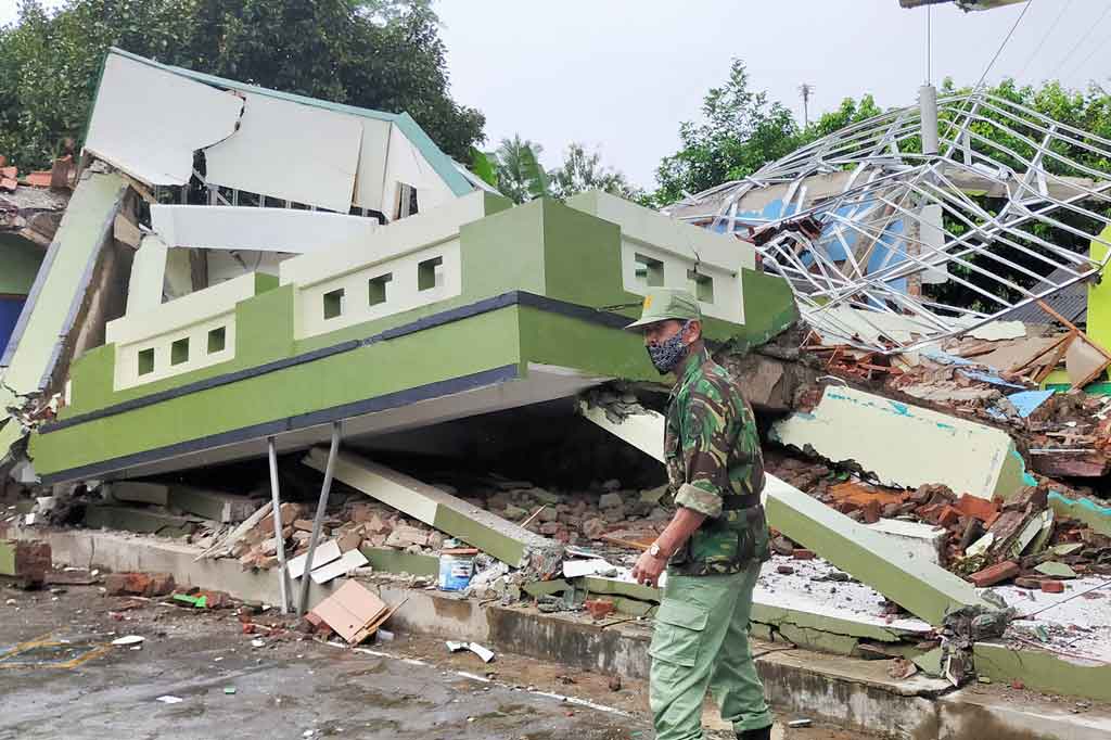 Petugas berjaga-jaga di dekat bangunan SDN Babakan Jeruk yang ambruk akibat pergerakan tanah, di Desa Singajaya, Kecamatan Cibalong, Kabupaten Tasikmalaya, Jawa Barat, Rabu, 10 Februari 2021.